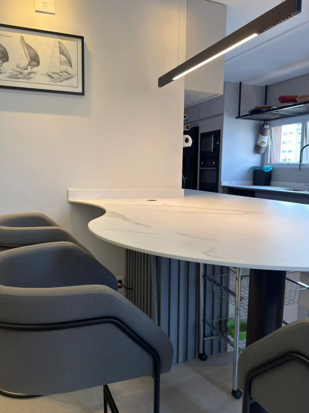 Integração de ambientes com bancada de mármore e iluminação