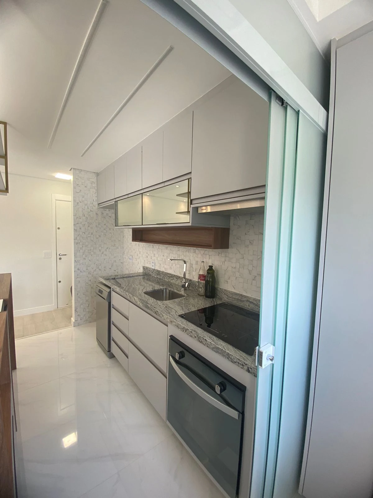 Cozinha com revestimento de pastilhas em apartamento reformado pela TAFT Engenharia